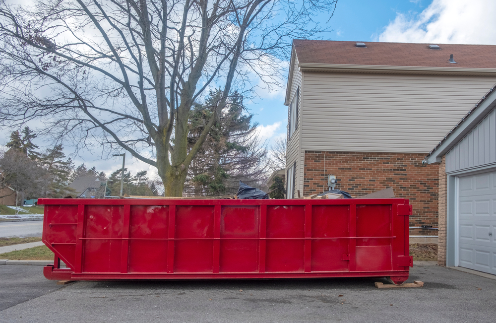 Red,Dumpster,Bin,On,The,Driveway,Of,A,Suburban,House